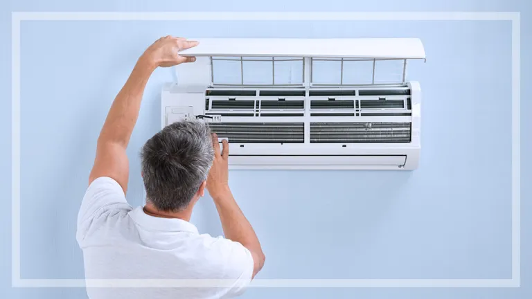 man looking at size of air conditioner on wall