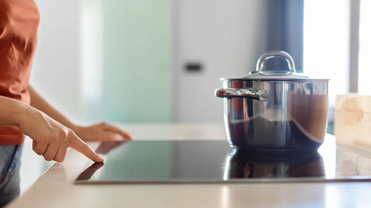 Person switching on an induction cooktop